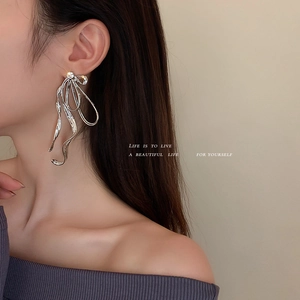 Boucles d'oreilles nœud en argent avec zircons sur mannequin pour un style élégant