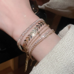Close-up of gold layered bracelet set with sparkling cubic zirconia and arrow details