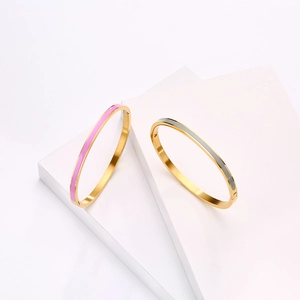 Elegant gold-plated stainless steel enamel bangles in pink and grey on geometric display