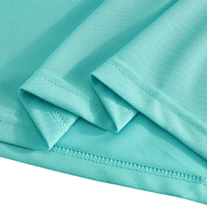 Macro view of breathable mesh fabric texture and double-stitched hem on the cyan polo shirt