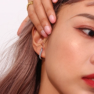 Close-up of silver earrings with pave-set cubic zirconia on a female model