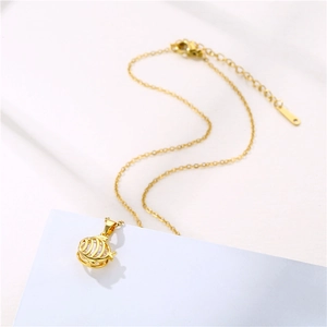 Elegant gold stainless steel fish pendant necklace with zircon stone on white background