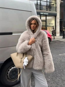 Women's light brown faux fur hooded coat styled with grey trousers and a tote bag