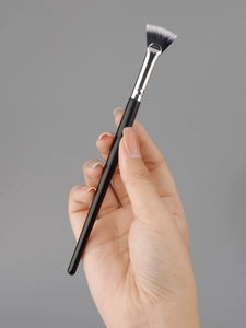 Detailed view of professional fan-shaped makeup brush with soft bicolored synthetic bristles