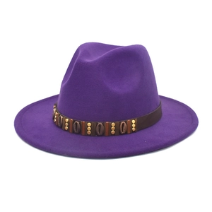 Detailed view of purple fedora hat featuring a dark band with shell and gold stud accents