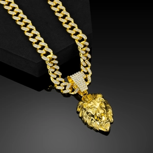 Macro shot of gold lion head pendant with sparkling rhinestones and cuban link chain