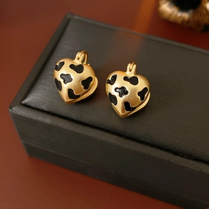 Macro detail of vintage heart earrings with gold metal and black leopard print texture