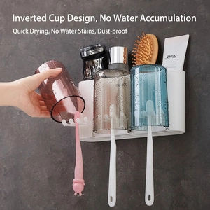 Wall-mounted bathroom organizer with three inverted cups and hooks for toothbrushes