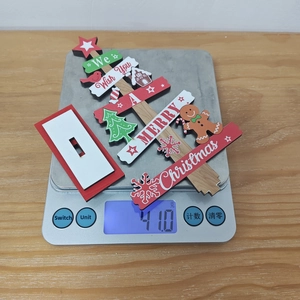 Detailed view of wooden Christmas tree decoration being weighed at 41g on a digital scale