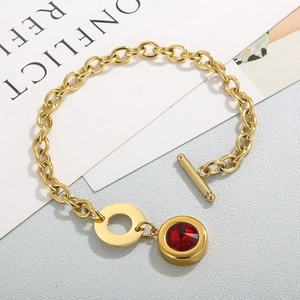 Detail of gold-plated stainless steel bracelet featuring a red zircon pendant and OT clasp