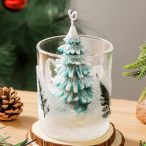 Handmade Christmas tree scented candle in a glass jar with festive decor and pine base