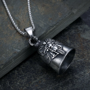 Macro shot of vintage silver motorcycle guardian bell pendant with winged skull carving