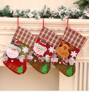 Detaillierte Ansicht hängender Weihnachtssocken mit Nikolaus und Schneemann am Kamin