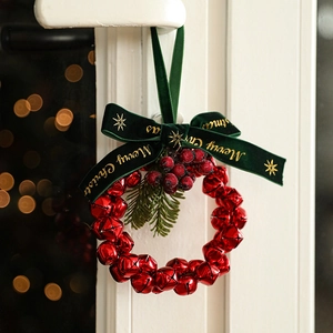 Christmas wreath with red metal bells, green velvet ribbon and Merry Christmas text