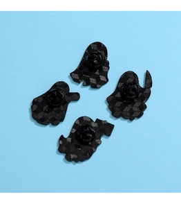 Detail of ghost-shaped pins featuring black metal texture and secure butterfly clutches