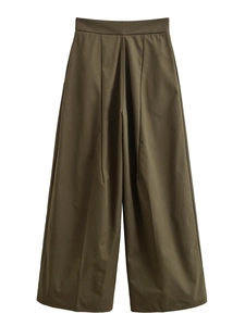 Detail of high waisted wide leg trousers in olive green with pleats and a relaxed fit