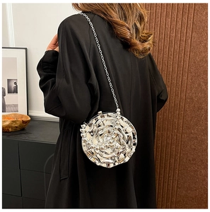 Silver 3D rose flower hard shell evening bag with metal chain strap worn by a model