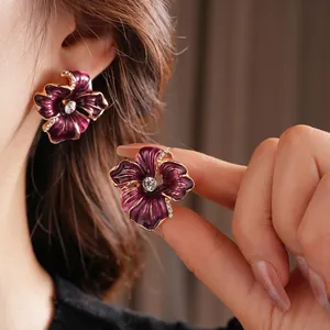 Vintage flower earrings with purple enamel petals and cubic zirconia stones in gold finish