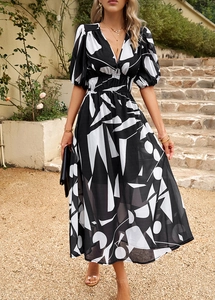 Détail du décolleté en V et de l'imprimé géométrique sur une robe midi élégante à taille haute