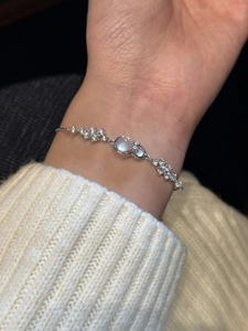 Detailed view of silver bow gourd bracelet with sparkling zircons and white gemstones