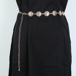 Close-up of golden metal waist chain featuring embossed coin charms and adjustable links