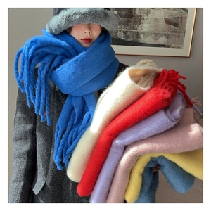 Detail showing the fluffy mohair texture and long fringe edges of thick winter scarves