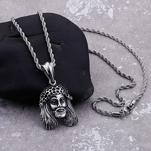 Vintage steel Jesus head pendant necklace with twisted rope chain on black rock