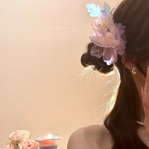 Dettaglio di un fermaglio per capelli floreale fatto a mano con petali in mesh e perle