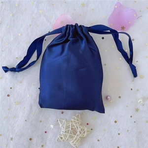 Detail of navy blue satin drawstring pouch for jewelry storage on decorative lace