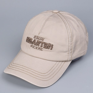 Close-up of letter embroidery and decorative stitching on beige cotton baseball cap