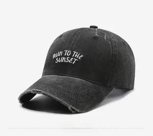 Detail of washed black baseball cap featuring vintage distressed holes and white embroidery