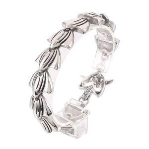 Vintage silver stainless steel bracelet featuring intricate leaf carvings on a display stand
