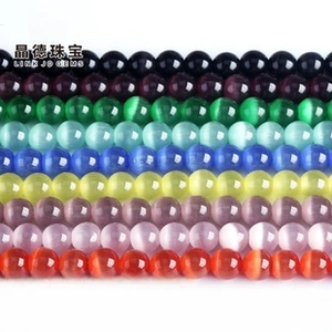 Close-up of polished colorful cat eye beads with chatoyancy effect for DIY jewelry