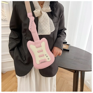 Detail of guitar-shaped crossbody bag in pink and beige with chic star studs and wide strap