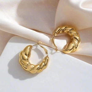 Polished 18K gold plated chunky twisted hoop earrings on an elegant textured backdrop