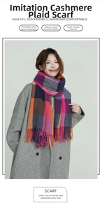 Detail of multi-color plaid cashmere-like scarf with soft long tassels on gray coat