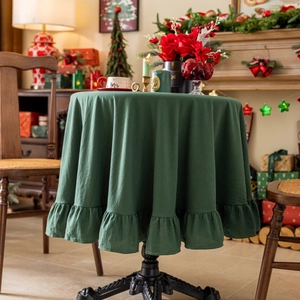Close-up of dark green ruffled table cloth hem with elegant cream style pleats