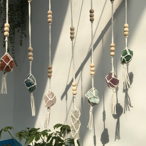 Detail of handcrafted bohemian wall hanging with natural crystals and cotton fringe