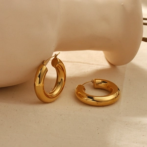 Polished 18k gold plated stainless steel chunky hoop earrings on artistic stand