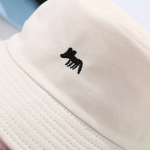 Minimalist beige cotton bucket hat featuring a black fox embroidery on thick twill fabric