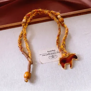 Bohemian woven rope necklace with amber style horse pendant and wooden beads