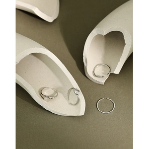 Set of four minimalist silver rings with zircons on a creative olive green background