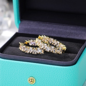 Macro shot of gold hoop earrings with pear-cut AAA cubic zirconia in a jewelry box