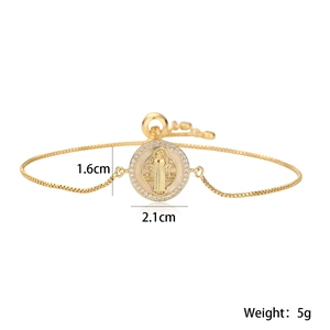 Detailed macro view of 18K gold plated St. Benedict medal bracelet with crystal accents