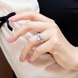 Macro shot of oval-cut zircon silver ring with four-prong setting and side micro-pave details