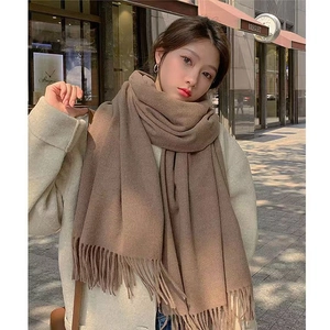 Detail of dark brown faux cashmere scarf with soft tassel trim and thick knit texture
