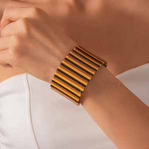 Detailed shot of an acrylic wide cuff bracelet with bold orange and black stripes