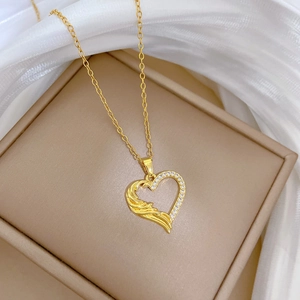 Detail of gold heart pendant with feather texture and sparkling pavé cubic zirconia stones