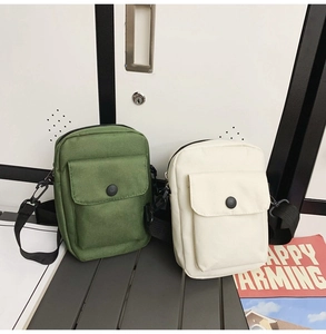 Detail of army green and cream canvas crossbody bags with adjustable straps