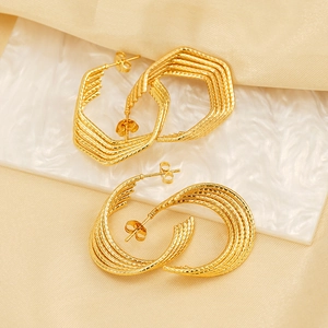 Elegant 18k gold plated geometric U-shaped earrings on marble with silk fabric